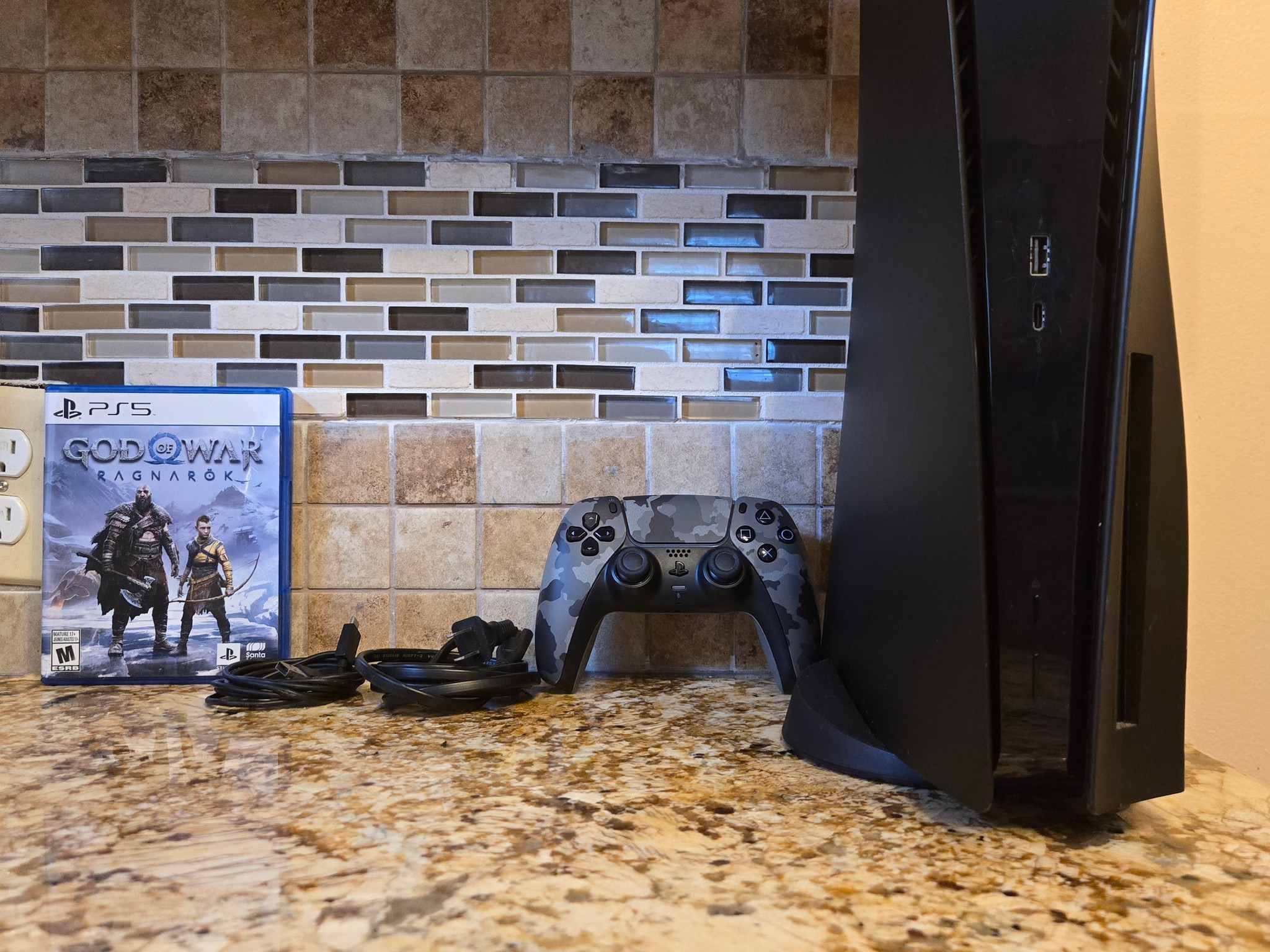 PS5 (Black Plates, Camo Controller) + God of War Ragnarök – $370
