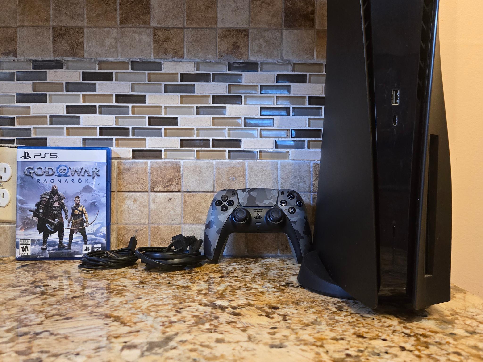 PS5 (Black Plates, Camo Controller) + God of War Ragnarök – $370