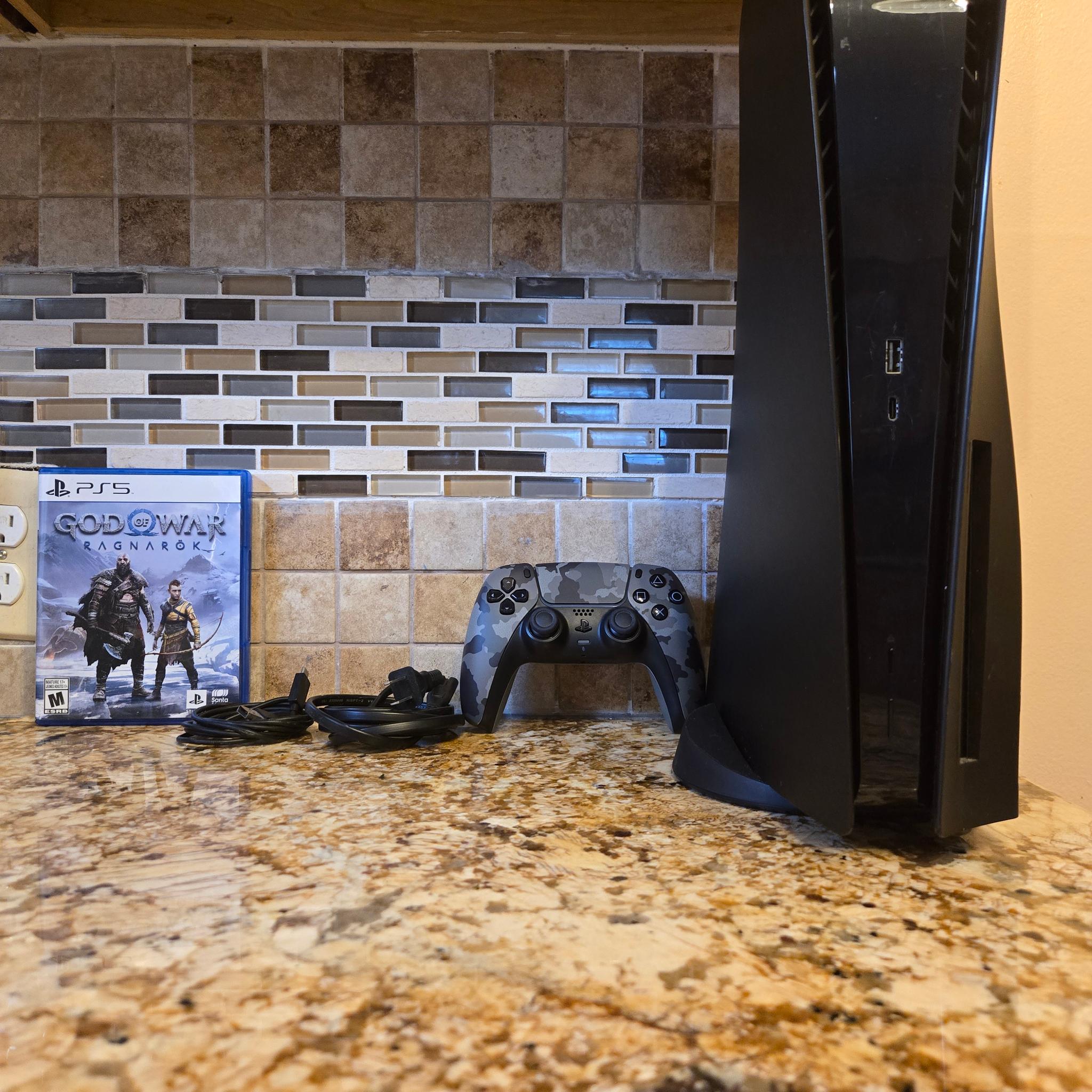 PS5 (Black Plates, Camo Controller) + God of War Ragnarök – $370